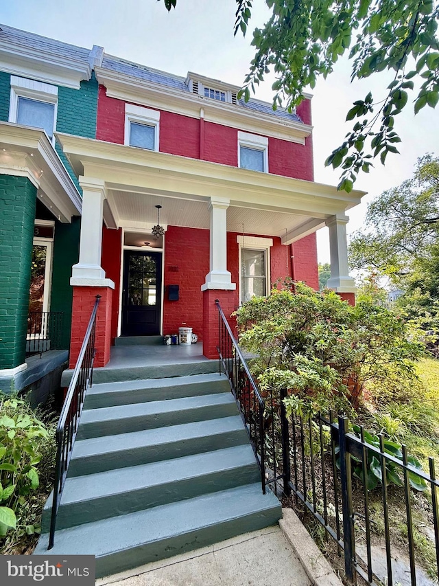 701 Kentucky Ave SE, Washington, DC 20003 - view of front facade featuring covered porch, brick siding, and mansard roof