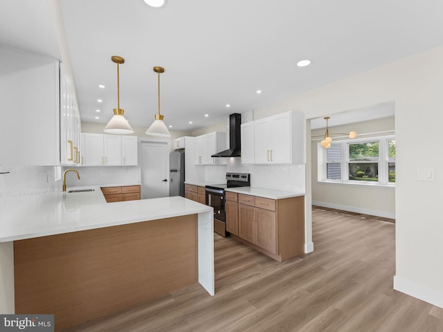 103 Hillcrest Ln, Willingboro, NJ 08046 - kitchen featuring stainless steel appliances, wall chimney range hood, tasteful backsplash, a peninsula, and light wood-style floors