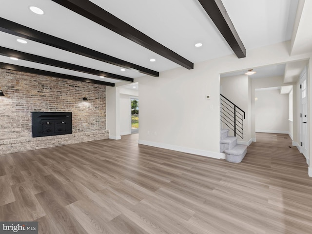 103 Hillcrest Ln, Willingboro, NJ 08046 - unfurnished living room featuring wood finished floors, beam ceiling, stairway, and a fireplace