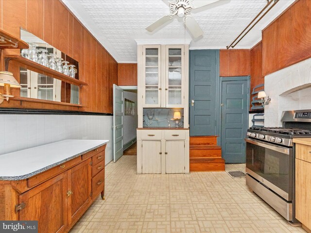 2700 Saint Paul St, Baltimore, MD 21218 - kitchen featuring gas range, open shelves, ceiling fan, decorative backsplash, and ornamental molding