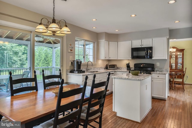 43076 Stonecottage Pl, Ashburn, VA 20147 - kitchen with black microwave, range, white cabinetry, dark wood finished floors, and recessed lighting