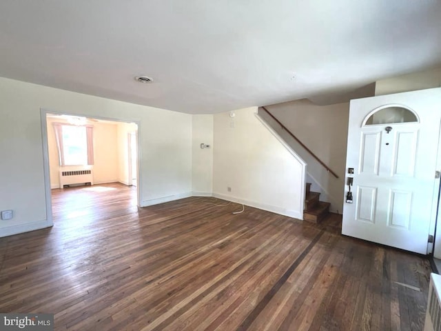 8544 Willow Oak Rd, Parkville, MD 21234 - unfurnished living room with radiator, dark wood-type flooring, and stairway