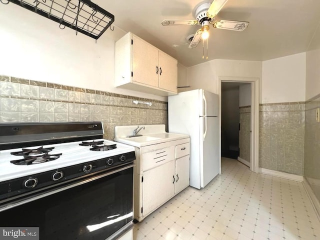 8544 Willow Oak Rd, Parkville, MD 21234 - kitchen with range with gas cooktop, freestanding refrigerator, light floors, a ceiling fan, and tile walls