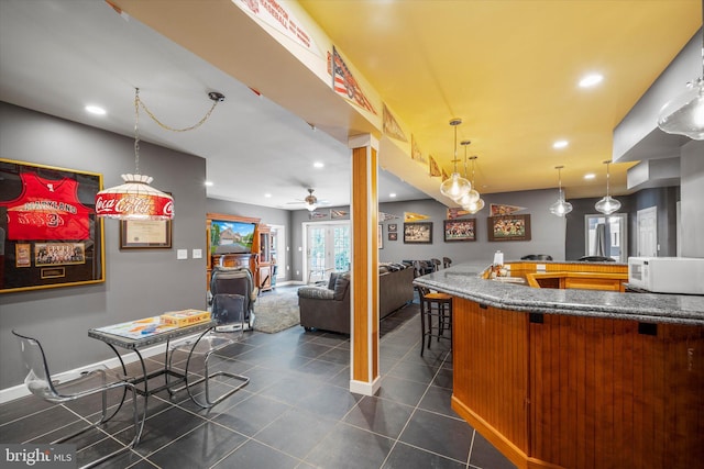 43146 Scenic Creek Way, Leesburg, VA 20176 - kitchen featuring open floor plan, dark tile patterned flooring, a breakfast bar area, white microwave, and recessed lighting
