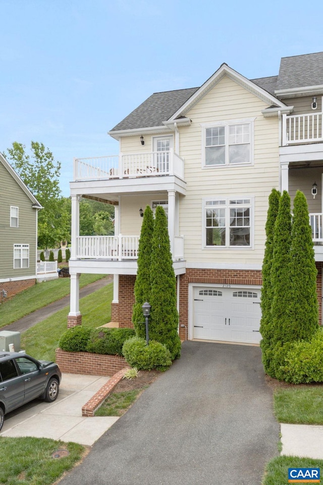 2126 Sundown Pl, Charlottesville, VA 22911 - view of front of property featuring driveway, a balcony, an attached garage, brick siding, and a shingled roof