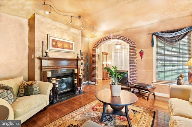 176 Windgate Dr, Chester Springs, PA 19425 - living room featuring a glass covered fireplace, wood finished floors, and arched walkways