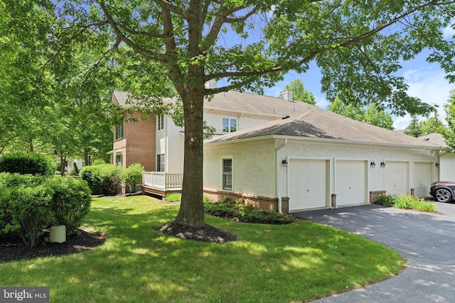 176 Windgate Dr, Chester Springs, PA 19425 - view of side of property with driveway, brick siding, an attached garage, a lawn, and stucco siding