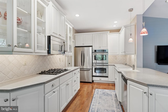 176 Windgate Dr, Chester Springs, PA 19425 - kitchen with appliances with stainless steel finishes, white cabinets, light wood-style floors, backsplash, and recessed lighting