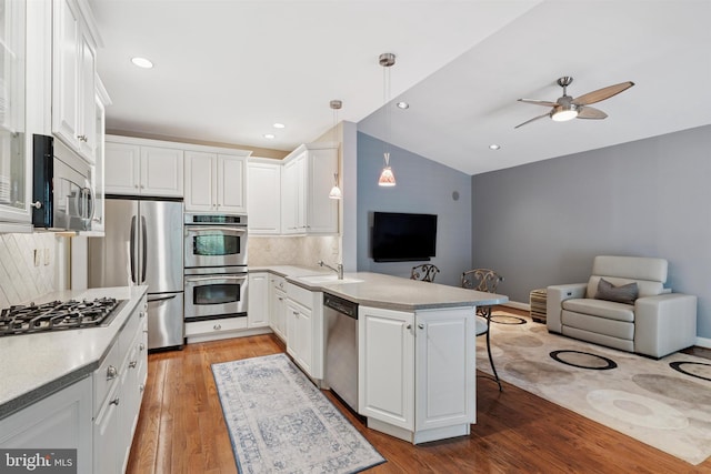 176 Windgate Dr, Chester Springs, PA 19425 - kitchen featuring stainless steel appliances, a peninsula, open floor plan, a kitchen bar, and vaulted ceiling