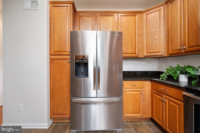 1201 Preserve Ln, Fredericksburg, VA 22401 - kitchen with stainless steel fridge with ice dispenser, stove, dark stone counters, and brown cabinetry