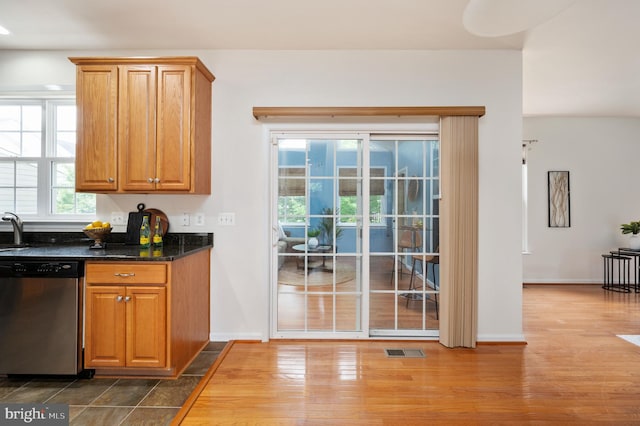 1201 Preserve Ln, Fredericksburg, VA 22401 - kitchen with stainless steel dishwasher, wood finished floors, brown cabinetry, and dark stone counters