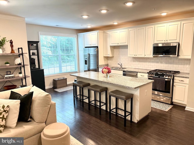23245 Milltown Knoll Sq Unit 103, Ashburn, VA 20148 - kitchen featuring stainless steel appliances, a breakfast bar area, a kitchen island, dark wood finished floors, and tasteful backsplash