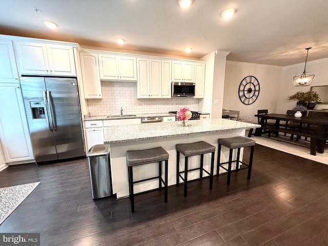 23245 Milltown Knoll Sq Unit 103, Ashburn, VA 20148 - kitchen featuring appliances with stainless steel finishes, a breakfast bar area, crown molding, dark wood finished floors, and decorative backsplash