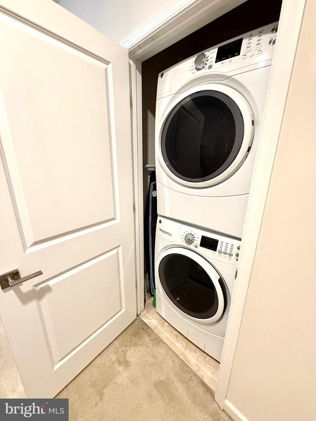23245 Milltown Knoll Sq Unit 103, Ashburn, VA 20148 - laundry area featuring stacked washing machine and dryer and light colored carpet