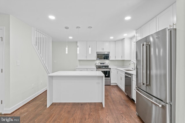 7724 Central Ave, Pasadena, MD 21122 - kitchen with appliances with stainless steel finishes, a kitchen island, white cabinets, dark wood-style flooring, and recessed lighting