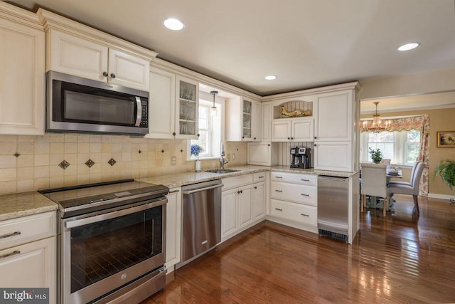 620 Laurel Rd, Springfield, PA 19064 - kitchen featuring appliances with stainless steel finishes, dark wood finished floors, a chandelier, light stone counters, and hanging light fixtures