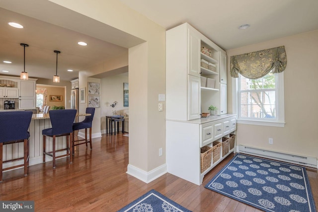 620 Laurel Rd, Springfield, PA 19064 - kitchen with a baseboard heating unit, dark wood-style flooring, a kitchen breakfast bar, white cabinetry, and recessed lighting