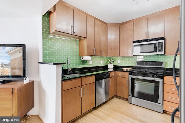 915 E St NW Unit 1103, Washington, DC 20004 - kitchen featuring appliances with stainless steel finishes, dark countertops, backsplash, and light wood-type flooring