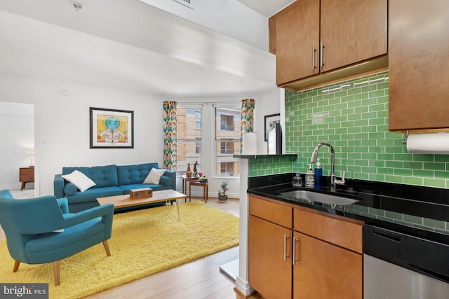 915 E St NW Unit 1103, Washington, DC 20004 - kitchen featuring dishwasher, decorative backsplash, light wood-style floors, dark countertops, and open floor plan