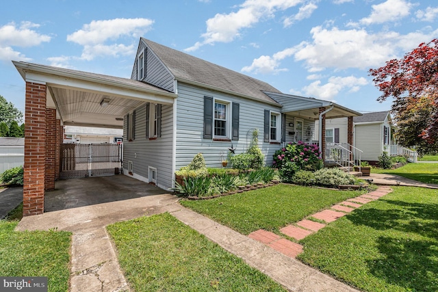 1815 Belle Ave, Dundalk, MD 21222 - view of front of house with a front lawn, concrete driveway, a porch, and a carport