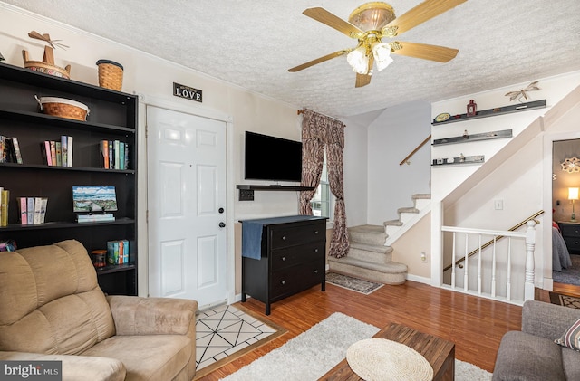 1815 Belle Ave, Dundalk, MD 21222 - living area featuring a textured ceiling, a ceiling fan, light wood-style flooring, stairway, and crown molding