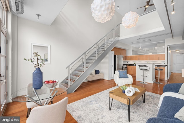 1390 Kenyon St NW Unit 524, Washington, DC 20010 - living room featuring stairs, a towering ceiling, light wood-style floors, and a chandelier