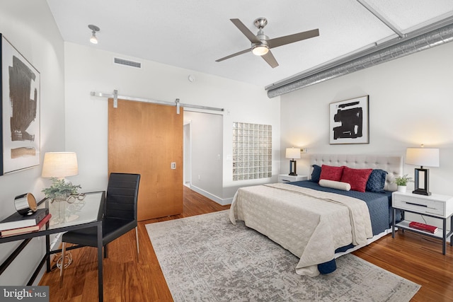 1390 Kenyon St NW Unit 524, Washington, DC 20010 - bedroom featuring a barn door, wood finished floors, and a ceiling fan