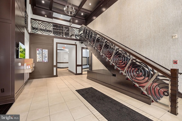 1390 Kenyon St NW Unit 524, Washington, DC 20010 - stairs with a towering ceiling, tile patterned flooring, coffered ceiling, wallpapered walls, and a chandelier