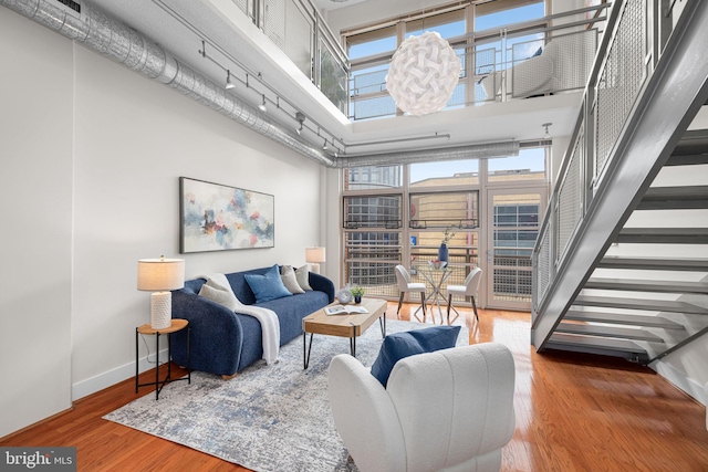1390 Kenyon St NW Unit 524, Washington, DC 20010 - living room with a towering ceiling, wood finished floors, stairway, and plenty of natural light
