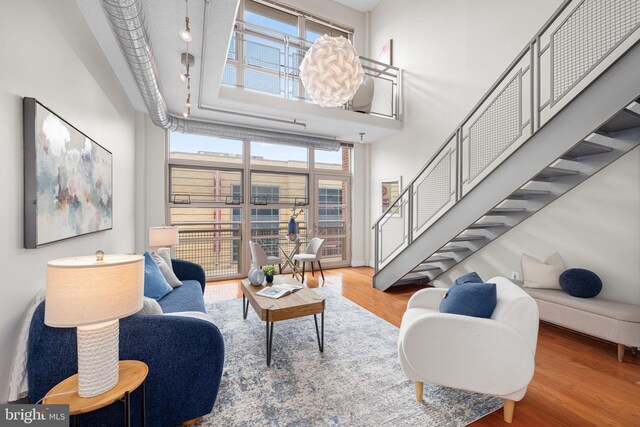 1390 Kenyon St NW Unit 524, Washington, DC 20010 - living room with wood finished floors, stairway, and a high ceiling