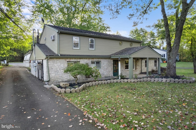 2965 Upper Ridge Rd, Pennsburg, PA 18073 - traditional-style home featuring stone siding, covered porch, a front lawn, asphalt driveway, and a garage