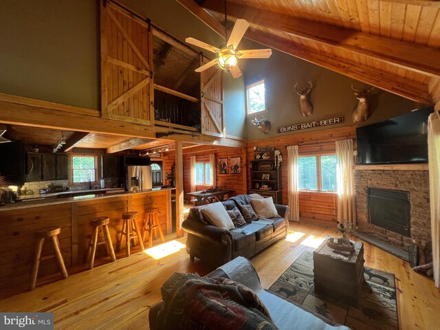 3081 French Ave, Cedarville, NJ 08311 - living room with high vaulted ceiling, light wood-style flooring, a wood ceiling with exposed beams, a fireplace, and a ceiling fan