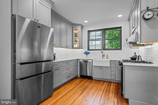 201 Locust St, Moorestown, NJ 08057 - kitchen with appliances with stainless steel finishes, gray cabinets, light wood-type flooring, backsplash, and light countertops