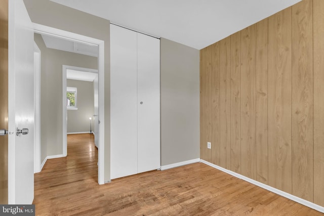 8000 Dellwood Ave, Glenarden, MD 20706 - unfurnished bedroom with wood finished floors, a closet, and wood walls