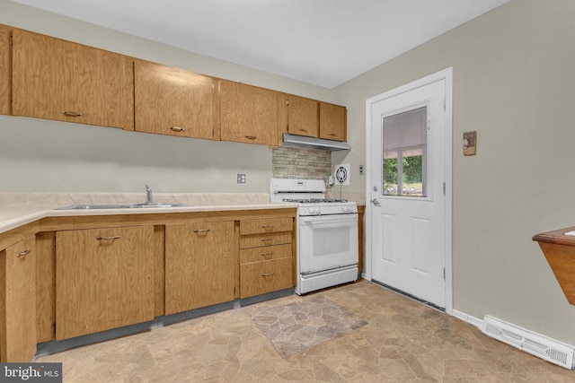8000 Dellwood Ave, Glenarden, MD 20706 - kitchen with white gas range, under cabinet range hood, light countertops, and light stone finish flooring