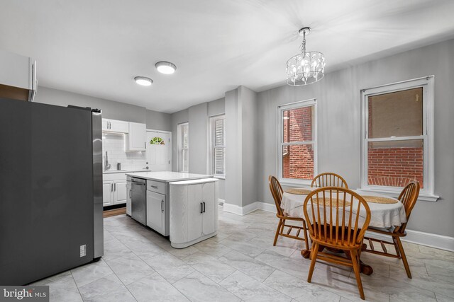 1002 W 9th St, Wilmington, DE 19806 - kitchen with appliances with stainless steel finishes, light countertops, a chandelier, a kitchen island, and white cabinets