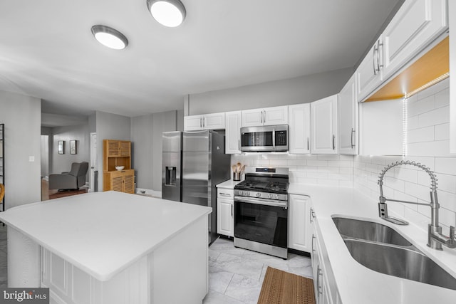 1002 W 9th St, Wilmington, DE 19806 - kitchen with appliances with stainless steel finishes, light countertops, tasteful backsplash, white cabinets, and a kitchen island