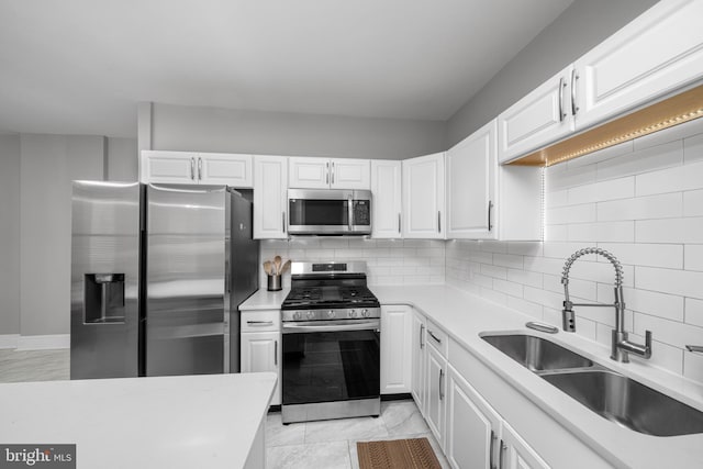 1002 W 9th St, Wilmington, DE 19806 - kitchen featuring stainless steel appliances, light countertops, backsplash, and white cabinets