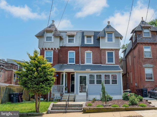 1002 W 9th St, Wilmington, DE 19806 - view of front of property with a shingled roof, covered porch, and brick siding