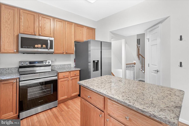 13102 Alpine Dr Unit 2502, Germantown, MD 20874 - kitchen with stainless steel appliances, light wood finished floors, and light stone countertops