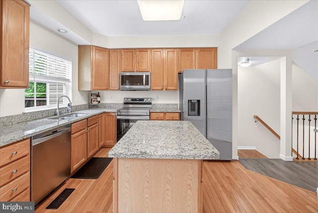 13102 Alpine Dr Unit 2502, Germantown, MD 20874 - kitchen featuring stainless steel appliances, light wood-style flooring, light stone counters, and a kitchen island