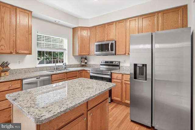 13102 Alpine Dr Unit 2502, Germantown, MD 20874 - kitchen featuring appliances with stainless steel finishes, light wood-style floors, light stone counters, and a kitchen island