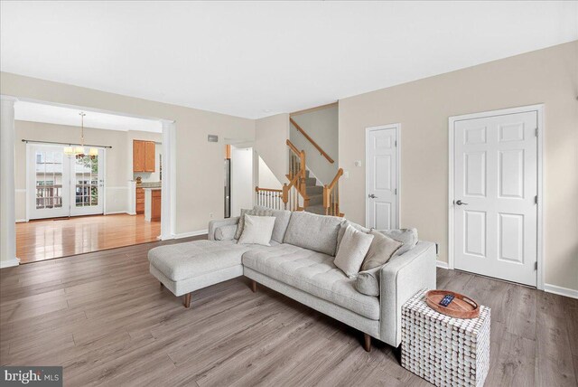 13102 Alpine Dr Unit 2502, Germantown, MD 20874 - living area with a chandelier, light wood finished floors, stairway, and ornate columns