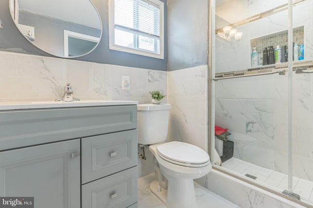 1009 Jansen Ave, Capitol Heights, MD 20743 - full bath with marble look tile flooring, tile walls, vanity, a marble finish shower, and wainscoting