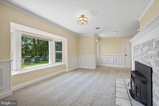 194 Harbor Dr, Lusby, MD 20657 - unfurnished living room featuring carpet flooring, a wood stove, ornamental molding, a decorative wall, and a wainscoted wall