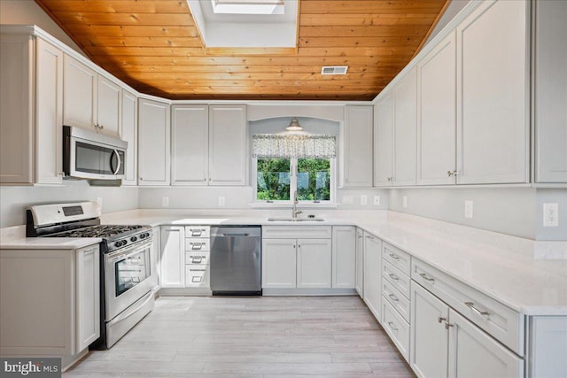 194 Harbor Dr, Lusby, MD 20657 - kitchen with appliances with stainless steel finishes, wood ceiling, light wood-style flooring, white cabinets, and light countertops