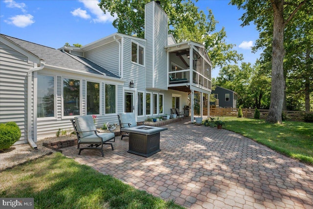 194 Harbor Dr, Lusby, MD 20657 - back of property featuring a patio, a chimney, an outdoor fire pit, a lawn, and a sunroom