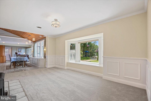 194 Harbor Dr, Lusby, MD 20657 - living area featuring wainscoting, vaulted ceiling, carpet flooring, crown molding, and a decorative wall