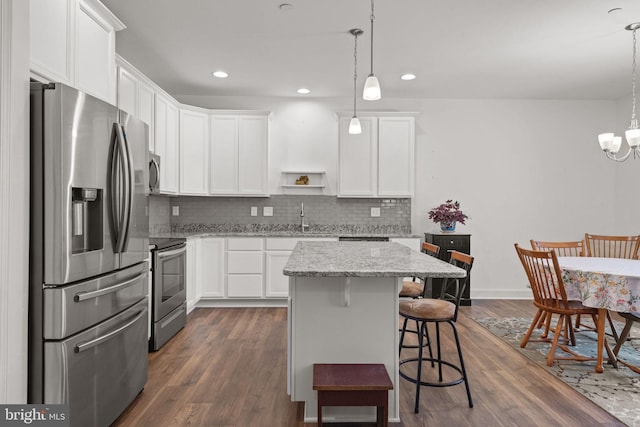 612 Cypress Dr Unit 51, Hanover, PA 17331 - kitchen with appliances with stainless steel finishes, white cabinetry, decorative backsplash, dark wood-type flooring, and a kitchen breakfast bar