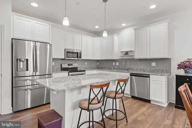 612 Cypress Dr Unit 51, Hanover, PA 17331 - kitchen with stainless steel appliances, a breakfast bar area, a center island, white cabinetry, and tasteful backsplash